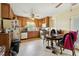 Well-lit kitchen area with wood cabinetry, white appliances, and linoleum flooring at 133 Montree Ln, Graham, NC 27253