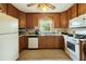 Kitchen area equipped with a stove, microwave and wooden cabinets at 133 Montree Ln, Graham, NC 27253
