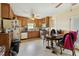 Functional kitchen features wood cabinets, white appliances, and adjacent dining area at 133 Montree Ln, Graham, NC 27253