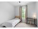 Bright bedroom featuring a twin bed, desk, and a window overlooking a green space at 139 Callowhill Ln, Durham, NC 27713