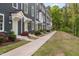 Long view of townhomes with light green doors and sidewalk at 139 Callowhill Ln, Durham, NC 27713