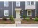 Close up of townhome with light green door, mulched landscaping and gray siding at 139 Callowhill Ln, Durham, NC 27713