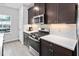 Modern kitchen featuring dark cabinets, stainless steel appliances, and white countertops at 139 Callowhill Ln, Durham, NC 27713