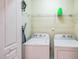 Functional laundry room with washer, dryer, storage shelf, and mounted ironing board at 140 Cedar Elm Rd, Durham, NC 27713
