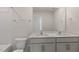 Bright bathroom features a double vanity with white countertop and cabinetry, and a large mirror at 144 Global Ave, Fuquay Varina, NC 27526