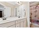Bright bathroom featuring a double vanity, framed mirrors, and a shower with a patterned curtain at 149 Country Mill Way, Fuquay Varina, NC 27526