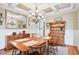 Formal dining room with hardwood floors, a classic chandelier, and ample natural light, ideal for Gathering meals and gatherings at 149 Country Mill Way, Fuquay Varina, NC 27526