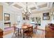 Stylish dining room featuring a coffered ceiling, chandelier, and large windows, creating an inviting and elegant space at 149 Country Mill Way, Fuquay Varina, NC 27526