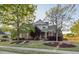 Inviting brick home boasts a lush front lawn, mature trees, and a welcoming facade on a sunny day at 149 Country Mill Way, Fuquay Varina, NC 27526