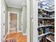 Walk-in pantry with organized shelving and food storage containers, plus access to the downstairs bathroom at 149 Country Mill Way, Fuquay Varina, NC 27526