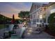 Outdoor stone patio with seating area, stone steps, and string lights at dusk at 149 Country Mill Way, Fuquay Varina, NC 27526