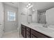 Clean bathroom featuring double sinks, dark wood cabinets, a large mirror, and natural light at 166 Yellow Jacket Rdg, Clayton, NC 27520