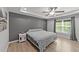 Comfortable bedroom with tray ceilings, a ceiling fan, a gray accent wall, and natural light at 166 Yellow Jacket Rdg, Clayton, NC 27520