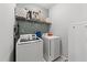 Efficient laundry room setup with modern washer, dryer, shelving, and neutral wall color at 166 Yellow Jacket Rdg, Clayton, NC 27520