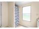 Bright bathroom featuring a shower with patterned curtain and a window for natural light at 1729 Crawford Rd, Graham, NC 27253