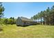 Rear exterior view of home with a spacious yard and tree-lined background at 1730 Willie Pace Rd, Burlington, NC 27217