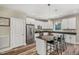 Bright kitchen featuring white cabinets, a stainless steel refrigerator, and an island with barstools at 1730 Willie Pace Rd, Burlington, NC 27217
