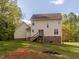 Spacious backyard with lush lawn, trees, and a charming deck accessible from the second story at 1850 Crissy Ln, Graham, NC 27253
