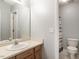 Bright bathroom with a single sink vanity, a large mirror, and a toilet with tiled flooring at 1850 Crissy Ln, Graham, NC 27253