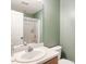Well-lit bathroom with a single sink vanity and a shower with a white shower curtain at 1850 Crissy Ln, Graham, NC 27253