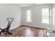 Neutral-toned room with wood floors, two windows and some exercise equipment at 1850 Crissy Ln, Graham, NC 27253