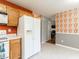 Eat-in kitchen with updated white appliances and unique accent wallpaper at 1850 Crissy Ln, Graham, NC 27253
