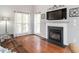 Bright living room featuring a fireplace, hardwood floors, and large windows with elegant white curtains at 1850 Crissy Ln, Graham, NC 27253