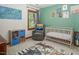 Bedroom features a cozy glider, decorative wall art, and a neutral-toned crib at 200 W Woodcroft Pkwy # 45C, Durham, NC 27713