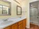 Bathroom featuring a double vanity, two mirrors and a glass door shower stall at 201 Lakewater Dr, Cary, NC 27511