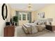 Nicely staged bedroom featuring a ceiling fan, large window with curtains, and hardwood flooring at 201 Lakewater Dr, Cary, NC 27511