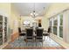 Dining room with a chandelier, and a pass-through view of the kitchen and with a beautiful rug at 201 Lakewater Dr, Cary, NC 27511