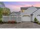 Charming home featuring gray siding, white garage door, and tasteful landscaping at sunset at 201 Lakewater Dr, Cary, NC 27511