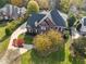 Aerial view of a brick home with mature trees, a circular driveway, and manicured landscaping at 204 Oxford Mill Ct, Cary, NC 27518