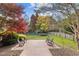Expansive backyard featuring a brick patio, lush lawn, mature trees, and a swing set at 204 Oxford Mill Ct, Cary, NC 27518