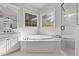 This primary bathroom has a glass shower, soaking tub, and dual windows for natural light at 204 Oxford Mill Ct, Cary, NC 27518