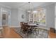 Dining room with table, six chairs, hardwood floor, and a large bay window at 204 Oxford Mill Ct, Cary, NC 27518