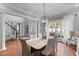 Open-concept dining area featuring hardwood floors, statement lighting, and bay windows at 204 Oxford Mill Ct, Cary, NC 27518