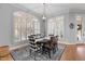 Dining room with large windows, hardwood floor, chandelier and seating for six at 204 Oxford Mill Ct, Cary, NC 27518