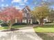 Charming brick home with manicured lawn and mature trees under a bright sky at 204 Oxford Mill Ct, Cary, NC 27518