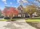 Charming brick home with manicured lawn and mature trees under a bright sky at 204 Oxford Mill Ct, Cary, NC 27518