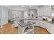 Kitchen with white cabinetry, granite countertops and kitchen island, and views of the backyard at 204 Oxford Mill Ct, Cary, NC 27518