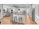 Spacious kitchen featuring an island with bar seating, stainless steel appliances and hardwood floors at 204 Oxford Mill Ct, Cary, NC 27518
