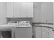 Bright laundry room featuring front load washer, dryer and ample cabinetry at 204 Oxford Mill Ct, Cary, NC 27518