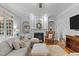 Comfortable living room with a fireplace, shelving, ceiling fan, and large windows at 204 Oxford Mill Ct, Cary, NC 27518