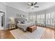 This primary bedroom features a ceiling fan, windows with wooden shutters, and hardwood flooring at 204 Oxford Mill Ct, Cary, NC 27518