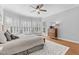 This primary bedroom has many windows with wooden shutters, hardwood flooring, and a ceiling fan at 204 Oxford Mill Ct, Cary, NC 27518