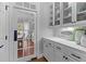 Butler's pantry featuring white cabinets, glass door cabinets, and granite countertops at 204 Oxford Mill Ct, Cary, NC 27518