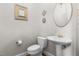 Bright powder room with toilet, sink and decorative mirror at 204 Oxford Mill Ct, Cary, NC 27518