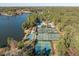 Aerial perspective of waterfront property with tennis courts, swimming pool, lake access, and lush surrounding forests at 222 Kelso Ct, Cary, NC 27511