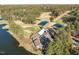 Stunning aerial view of a waterfront property with a golf course, clubhouse, and tented area, surrounded by a lake at 222 Kelso Ct, Cary, NC 27511